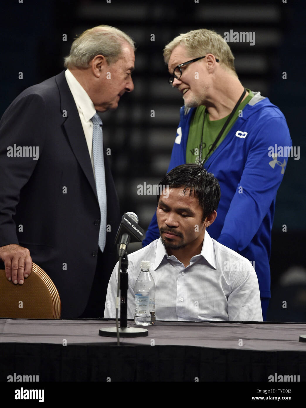 Manny Paciquiao sits, while his promotor, Bob Arum, left, and trainer, Freddie Roach, speak with each other before  a news conference after Paciquiao's welterweight unification bout against Floyd Mayweather Jr. at MGM Grand Garden Arena Saturday, May 2, 2015, in Las Vegas, Nevada. Mayweather won with an unanimous decision after the 12 round fight. Photo by David Becker/UPI Stock Photo