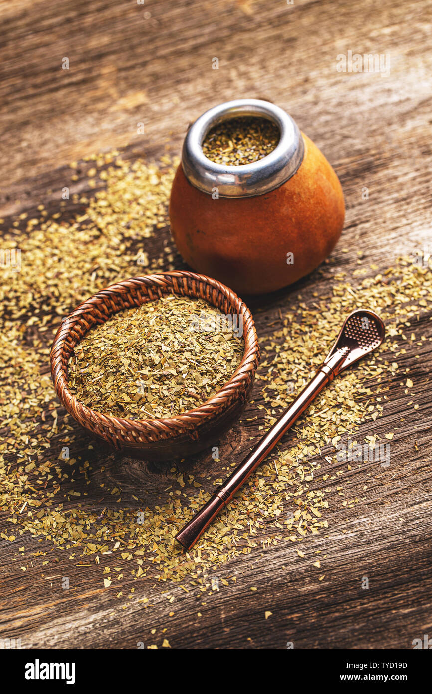 Pile of mate tea leaves and mate tea drink served in calabash gourd