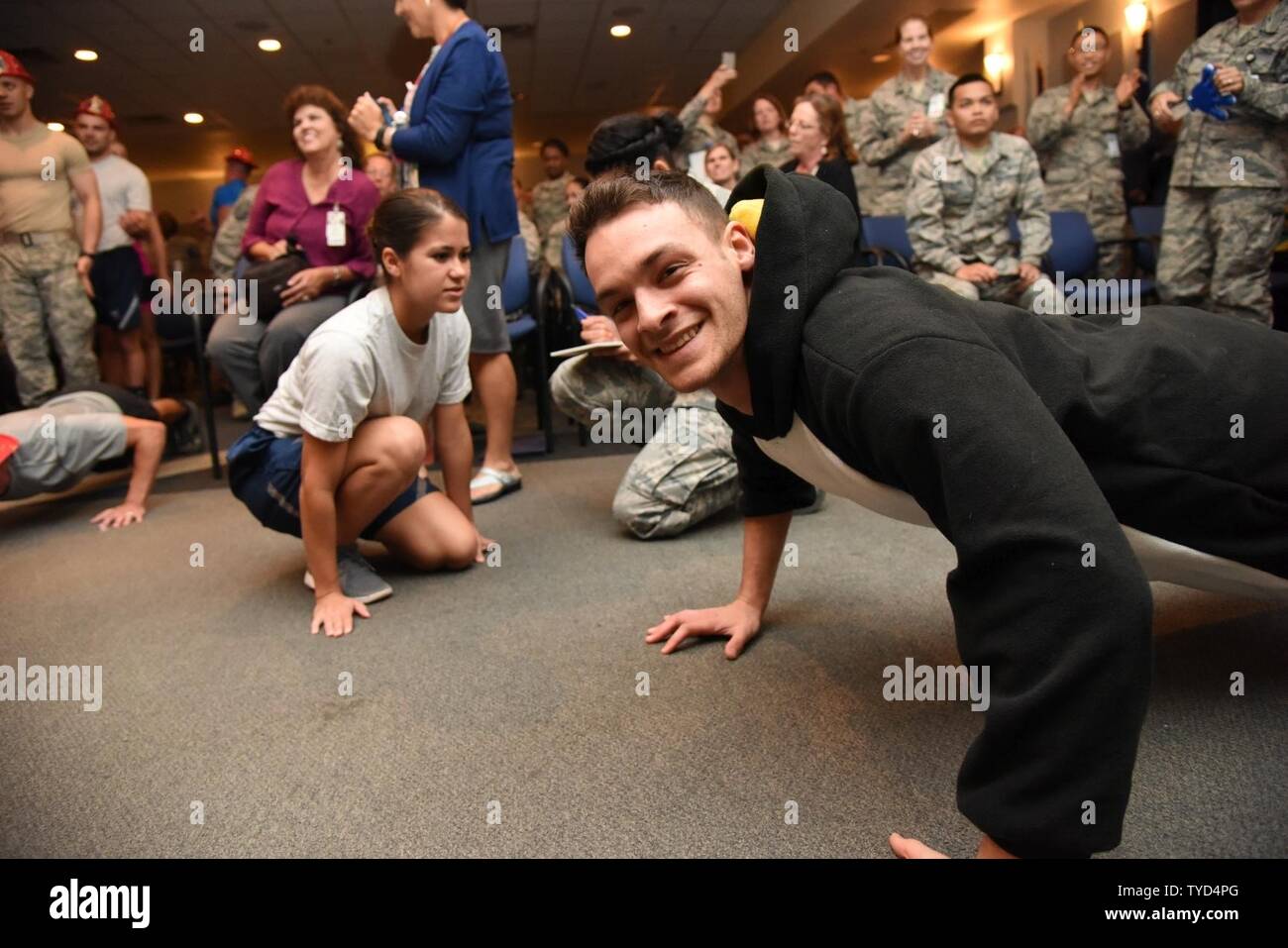 Airman 1st Class Garrett Redmond, 81st Diagnostic and Therapeutics Squadron radiology technician, smiles while doing push-ups during the 81st Medical Group Push-up Competition at the Keesler Medical Center Don Wylie Auditorium Nov. 1, 2016, on Keesler Air Force Base, Miss. Seven five-person teams competed in the event pushing out a total of 6,272 push-ups. The 81st Dental Squadron was this year’s winner with 1,127 push-ups. The Airmen who participated in the event raised money to support the Krewe of Medics Mardi Gras Ball. Stock Photo