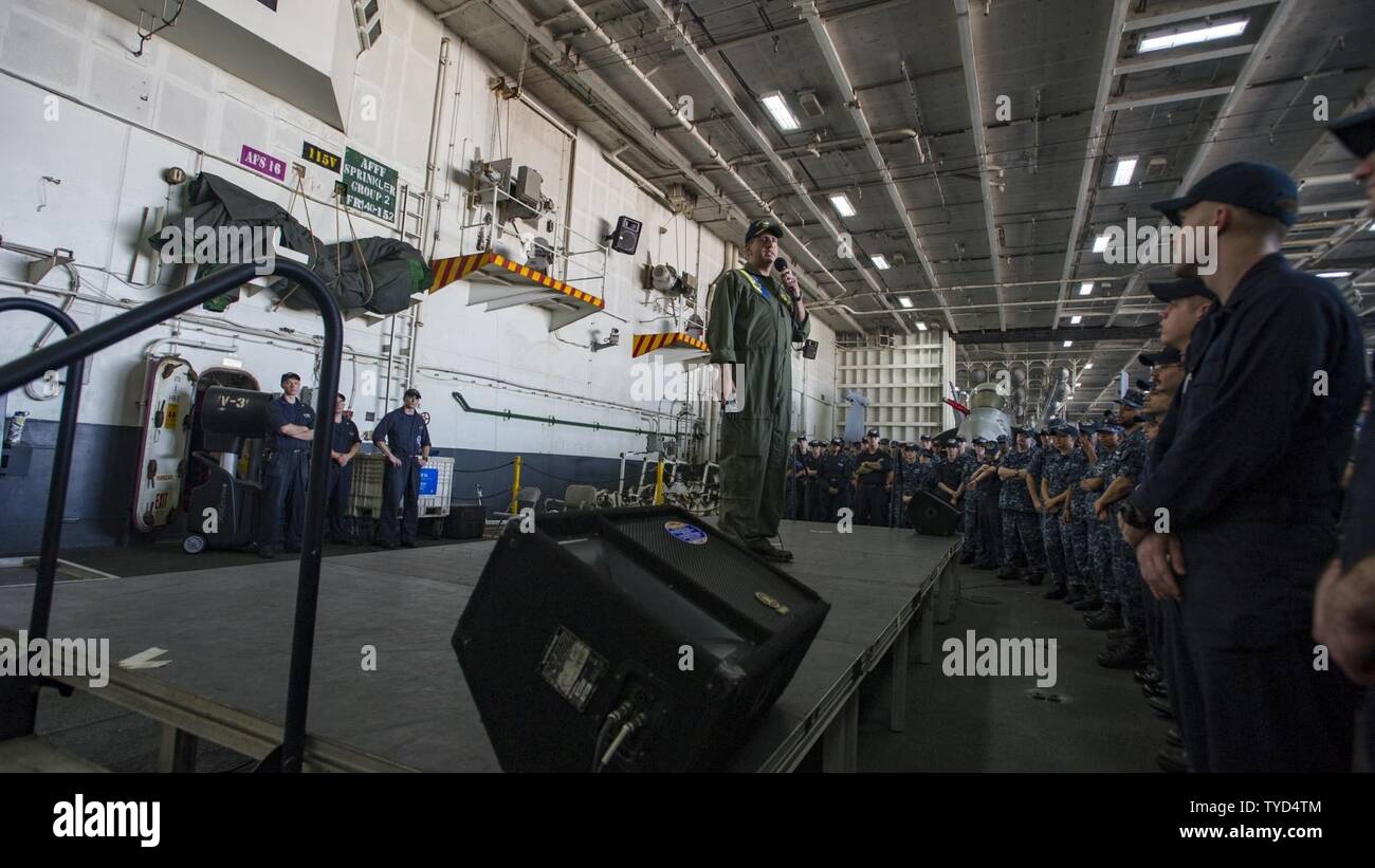 Bahrain (Nov 1, 2016) Executive Officer Capt. Robert Aguilar speaks in the hangar bay of the aircraft carrier USS Dwight D. Eisenhower (CVN 69) (Ike). Ike and its Carrier Strike Group are deployed in support of Operation Inherent Resolve, maritime security operations and theater security cooperation efforts in the U.S. 5th Fleet area of operations. Stock Photo