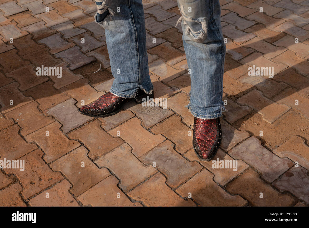 A migrant wears a cowboy belt buckle at a migrant shelter in Matamoros,  Mexico January 25, 2019. Some of these migrants were living in the United  States and were picked up for