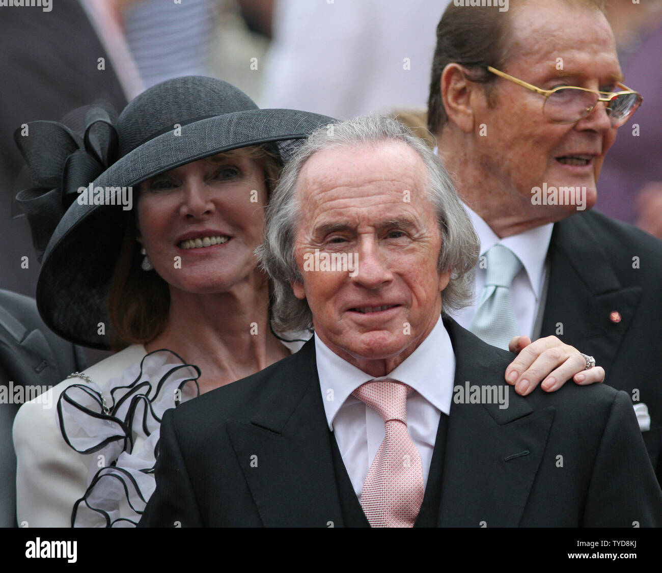 Sir Jackie Stewart (C), his wife Helen (L) and Sir Roger Moore depart from the Prince's Palace after the religious marriage ceremony of Prince Albert II and Princess Charlene in Monte Carlo, Monaco on July 2, 2011.  The Prince and Princess took part in a civil wedding ceremony yesterday.   UPI/ David Silpa Stock Photo