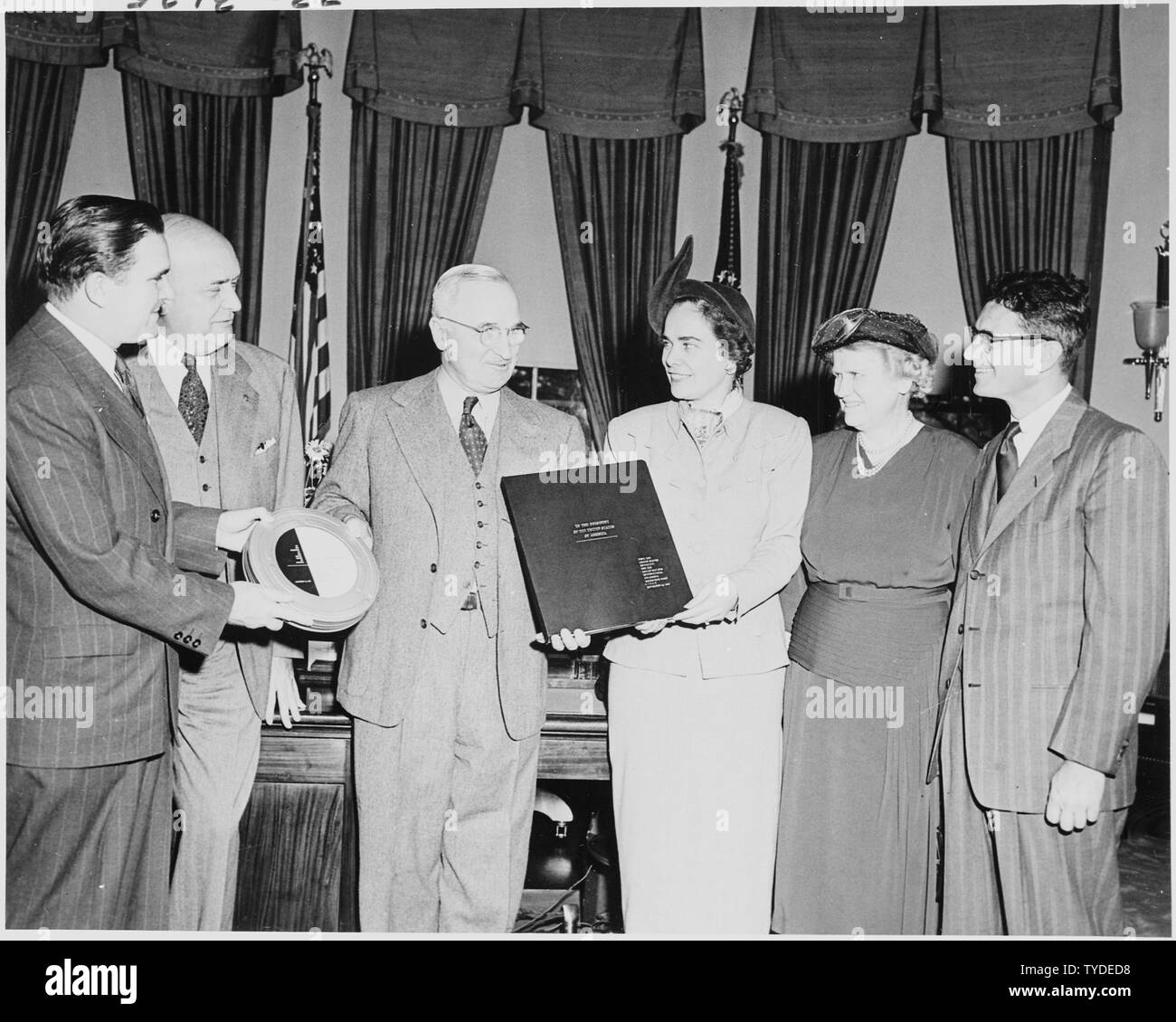 Photograph of President Truman in the Oval Office, receiving a report to the nation on the work of the United Nations International Children's Emergency Fund (UNICEF), prepared by the United States Committee for UNICEF; (from left to right) Under Secretary of State James Webb; Secretary of Defense Louis Johnson; the President; Mrs. Mary Lord, chairman of the U.S. Committee for UNICEF; Miss Katharine Lenroot, chief of the Children's Bureau and U.S. delegate to UNICEF; and Dallas Dort, Special Assistant to the Assistant Secretary of State for Economic Affairs. Stock Photo