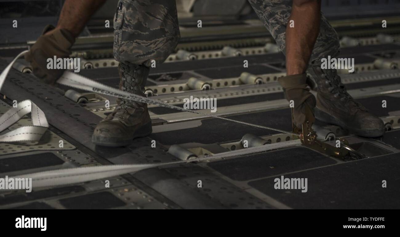 Senior Airman Zephaniah Valdez, 8th Expeditionary Air Mobility Squadron ramp transportation journeyman, prepares to pull a pallet into an 816th Expeditionary Airlift Squadron C-17 Globemaster III in support of Operation Freedom’s Sentinel Nov. 3, 2016. The operation focuses on training, advising, and assisting the Afghan Security Institutions and Afghan National Defense and Security Forces in order to build their capabilities and long-term sustainability. Stock Photo