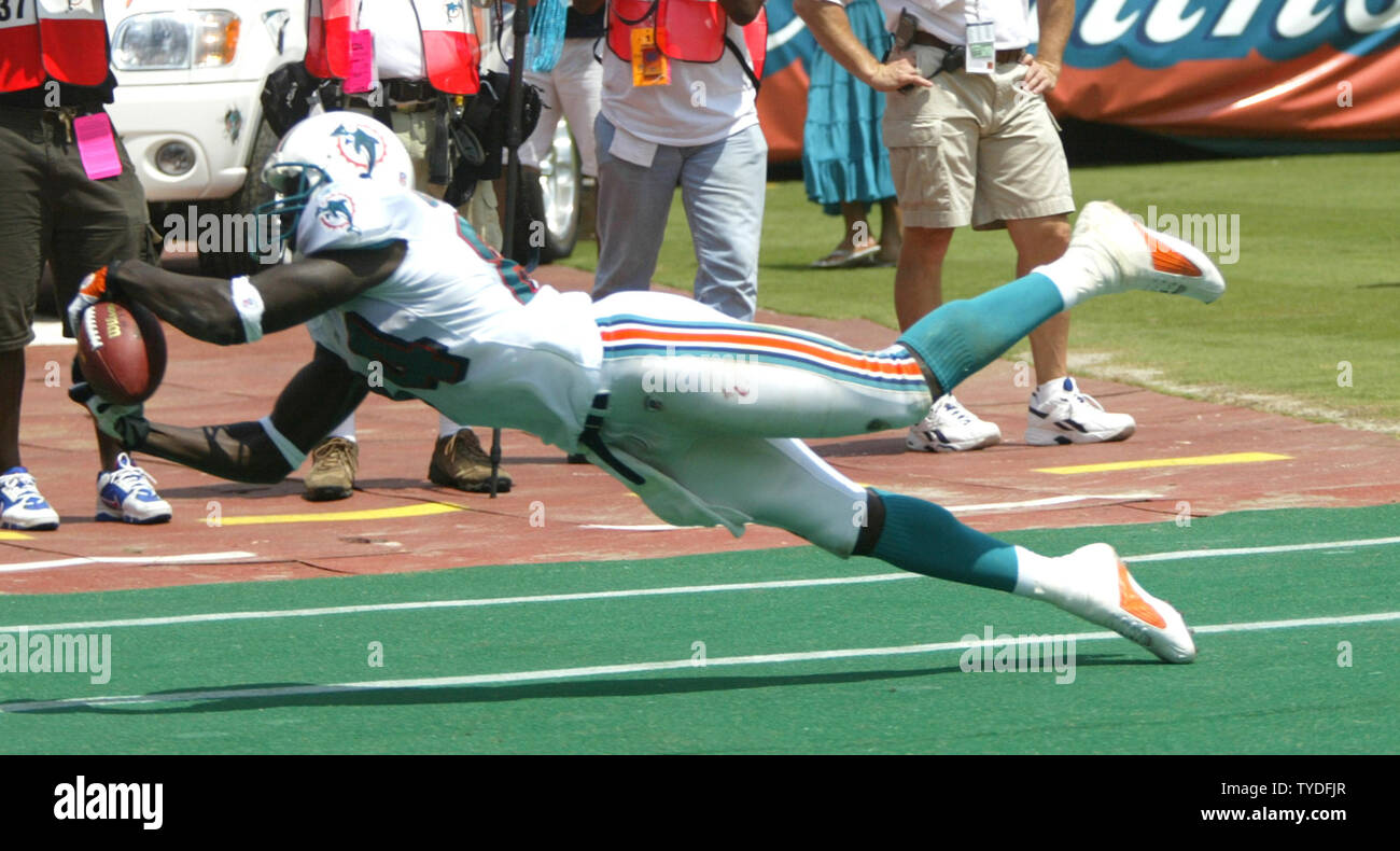 Miami Dolphins Wide Receiver Chris Chambers (84) is tackled by Arizona  Cardinals Duane Starks (28) on November 7, 2004 at Pro Player Stadium in  Miami, Fl. The Arizona Cardinals beat the Miami