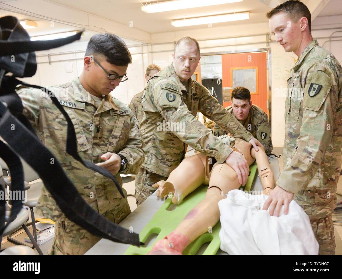 U.S. Army Soldiers, 28th Combat Support Hospital, prepare to remove a simulated trauma patient from a backboard during the Trauma Nursing Core Course hosted by the 28th CSH near Baghdad, Iraq, Nov. 2, 2016. This is the first time TNCC, a highly sough-after trauma training course for nurses, has been conducted by a unit deployed in support of Operation Inherent Resolve. Effective and comprehensive training is key for deployed medical personnel to preserve the health of Coalition forces working to weaken and defeat Islamic State in Iraq and the Levant. Combined Joint Task Force-Operation Inheren Stock Photo