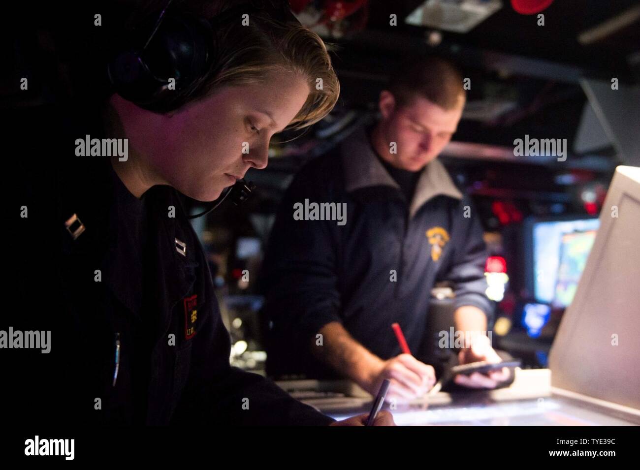 PHILIPPINE SEA (Nov. 3, 2016) Lt. JoAnna Kyle, left, and Petty Officer 2nd Class Aaron Ernsberger, right, assigned to the forward-deployed Arleigh Burke-class guided-missile destroyer USS McCampbell (DDG 85), stand watch in the combat information center. McCampbell is on patrol in the Philippine Sea with Carrier Strike Group Five (CSG 5) supporting security and stability in the Indo-Asia-Pacific region. Stock Photo