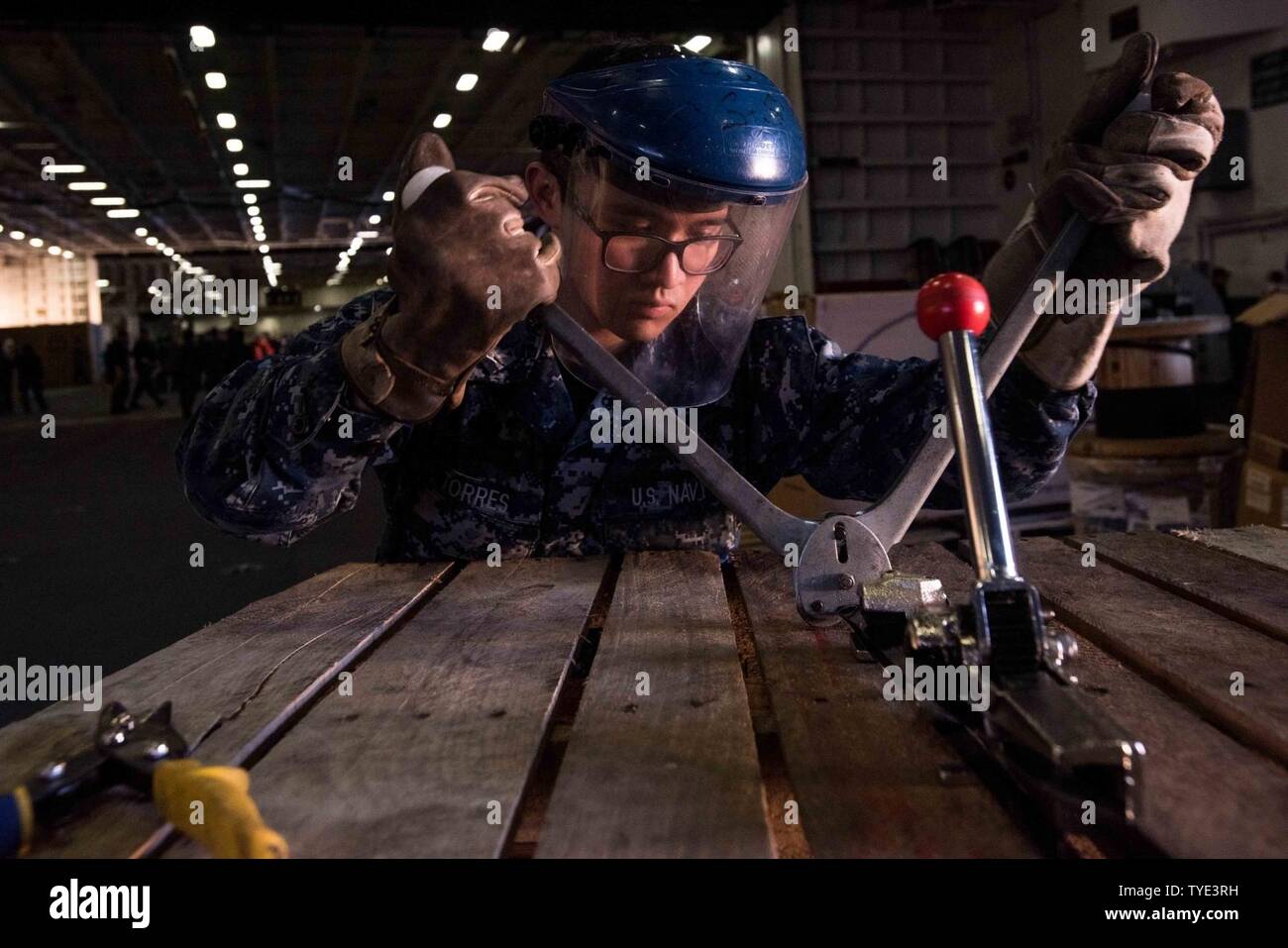 Washington (Nov. 3, 2016) Petty Officer 3rd Class Miguel Torres, from University Place, Washington, secures banding to a stack of pallets in USS John C. Stennis' (CVN 74) hangar bay. John C. Stennis is conducting a scheduled maintenance availability at Naval Base Kitsap-Bremerton. Stock Photo