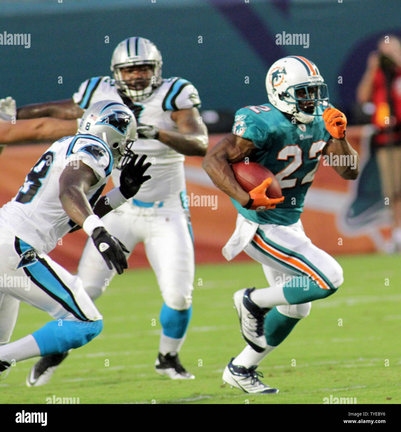 Miami Dolphins running back Reggie Bush (22) pulls three Houston Texans  defenders, Johnathan Joseph (24), Danieal Manning (38) and Glover Quin,  left, for a first down in the first quarter of an