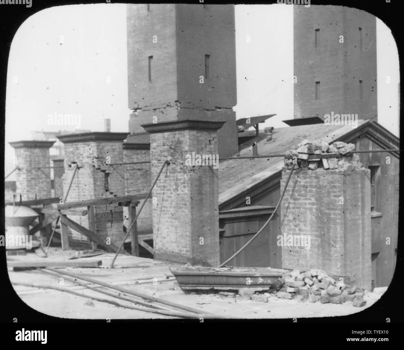 Photograph of damage done to the San Francisco Mint chimneys during the 1906 Earthquake. Smaller chimneys from the melting furnaces are in the foreground. Larger chimneys connected to the Mint's main engine and boiler are in the background. Stock Photo
