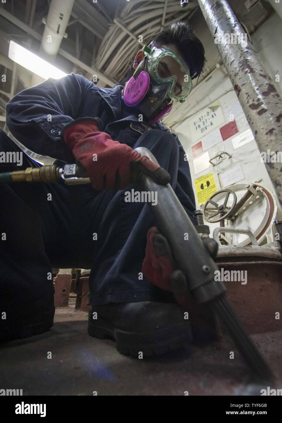 DIEGO (Nov. 04, 2016) Petty Officer 3rd Class Charles Cyphers uses a needle gun to remove rust