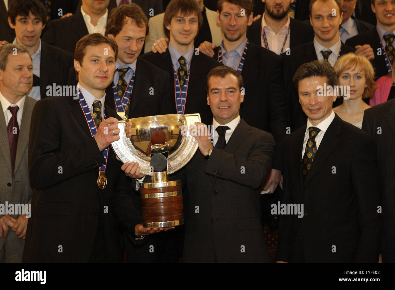 Russian President Dmitry Medvedev (C) holds the World Hockey Championships trophy with captain Alexei Morozov (L) and coach Vyacheslav Bykov (R) during his meeting with the national ice hockey team in the Kremlin in Moscow on May 12, 2009. In the final match on Sunday Russia beat Canada 2-1 and won the gold-medal of the ice hockey world championships. (UPI Photo/Anatoli Zhdanov) Stock Photo