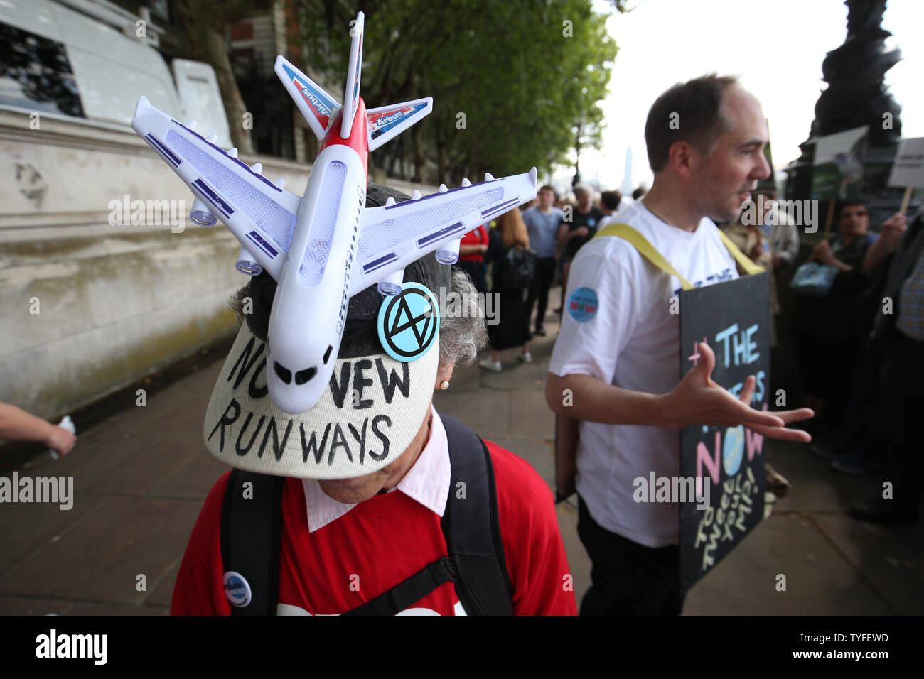 A climate activist wears a hat saying 'no new runways', as a group of them walk along the Southbank on their way to join the lobby of Parliament on taking action on climate change and environmental protection in Parliament Square, Westminster, London. Stock Photo