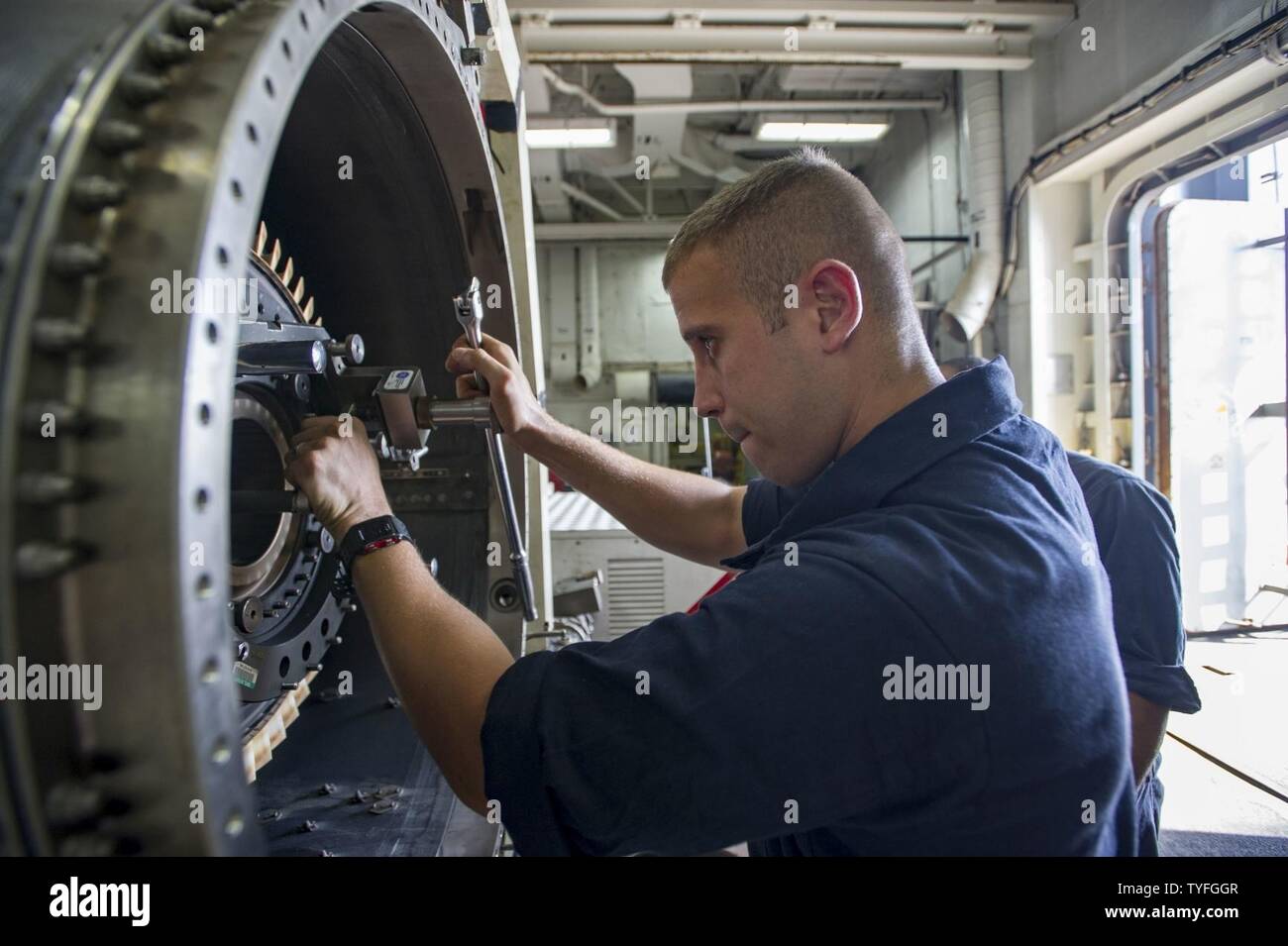 GULF (Nov 6, 2016) Seaman Jose Torrech, from Puerto Rico, conducts maintenance on the high-pressure turbine on a jet engine in the jet shop of the aircraft carrier USS Dwight D. Eisenhower (CVN 69) (Ike). Torrech serves aboard Ike as an aviation machinist’s mate and is responsible for inspecting, troubleshooting, fabricating and maintaining jet engines. Ike and its Carrier Strike Group are deployed in support of Operation Inherent Resolve, maritime security operations and theater security cooperation efforts in the U.S. 5th Fleet area of operations. Stock Photo