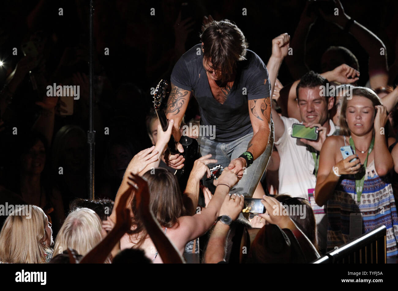 Country music artist Keith Urban signs his guitar and gives it to a fan  during his performance at the CMA Music Festival in Nashville on June 14,  2015. Photo by John Sommers