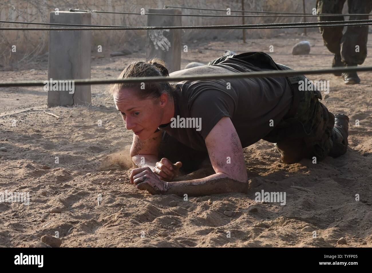 U.S. Navy Lt. Cmdr. Brighid Clark, Combined Joint Task Force-Horn of Africa Civil Affairs, navigates a low-crawl obstacle during a mud run hosted by the French military in Djibouti, Djibouti, Nov. 6, 2016. The event allowed coalition forces from France, Japan and the United States to interact and build camaraderie while navigating a five kilometer course. The French 5th Marine Regiment team took first place. Combined Joint Task Force-Horn of Africa is a multinational effort to conduct theater security cooperation, combat violent extremism and enable freedom of movement within East Africa in or Stock Photo