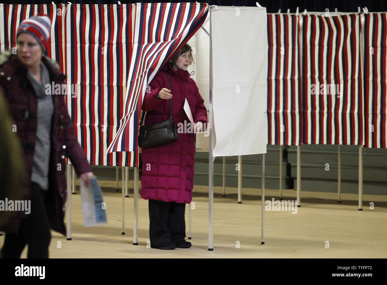 JoanneHajduk (C) emerges from a voting booth after casting her vote in the Presidential primary at the Gilbert H. Hood Middle School in Derry, New Hampshire on February 9, 2016.  Photo by Matthew Healey/UPI Stock Photo