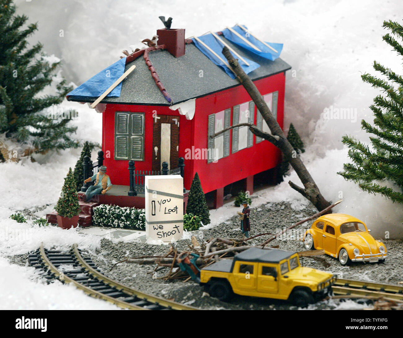 Tiny figures clamber over bluetarped roofs in a Christmas village
