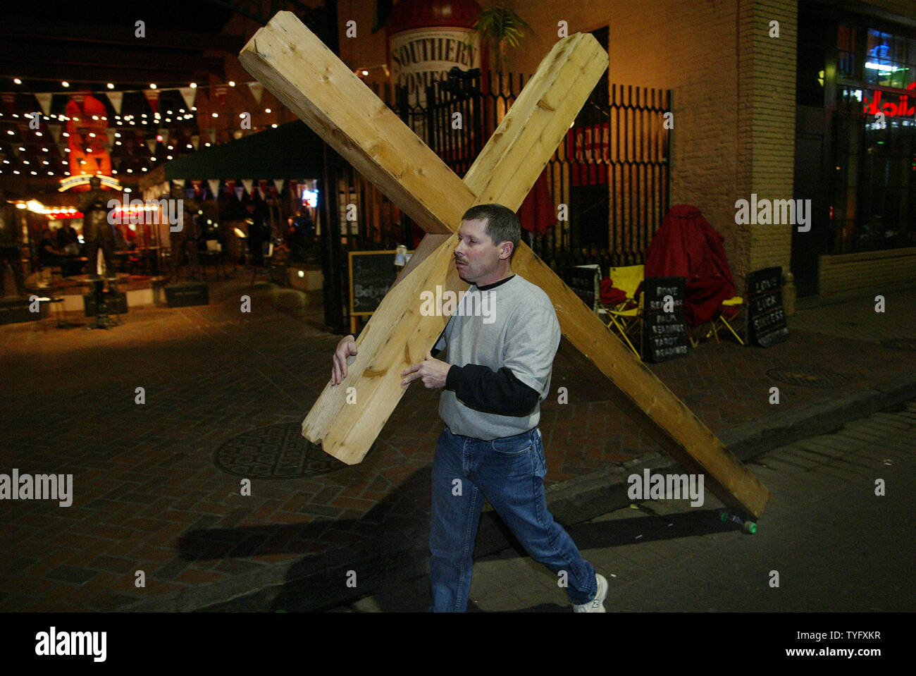 Paul Campbell of Anderson, Missouri walks down Bourbon Street in the French Quarter district of New Orleans with a large wooden cross February 23, 2006. While most visitors come to Carnival to party and have a good time, Campbell said he was here to save the souls of sinners.  (UPI Photo/A.J. Sisco) Stock Photo