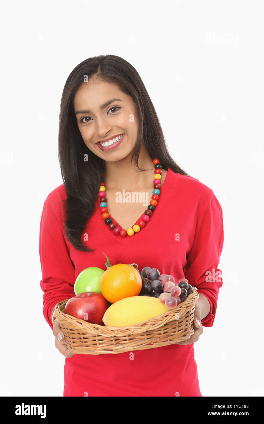 Teenage girl holding fruit basket and smiling Stock Photo - Alamy