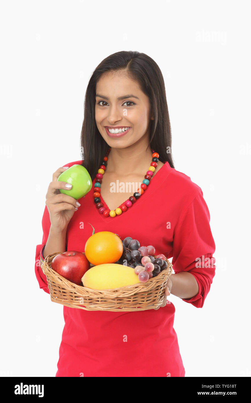 Teenage girl holding fruit basket and smiling Stock Photo - Alamy