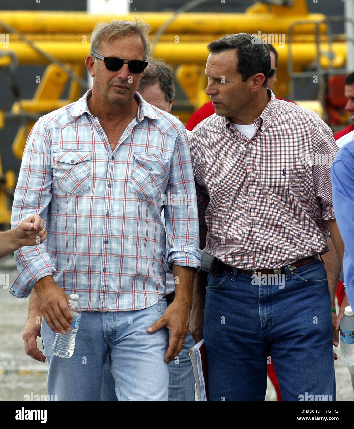 Kevin Costner, left, actor and founding partner of Ocean Therapy, listens to Doug Suttles,  chief operating officer of BP Exploration and Production, before a press conference in Port Fourchon, Louisiana, June 18, 2010. BP has purchased a centrifuge from Ocean Therapy that separates oil and water.   UPI/A.J. Sisco.. Stock Photo