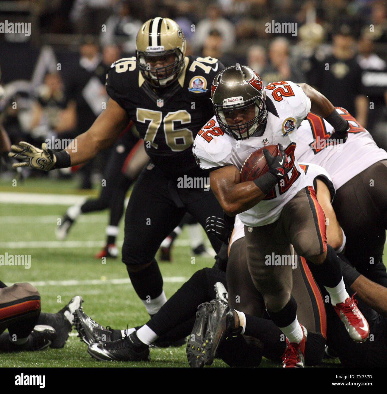 Tampa Bay Buccaneers running back Doug Martin (22) is chased through the  backfield by New Orleans Saints defensive tackle Akiem Hicks (76) at the  Mercedes-Benz Superdome in New Orleans, Louisiana on December