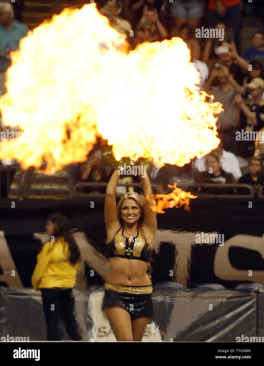 A New Orleans Saints cheerleader appears to be waving flaming pom poms  during the introduction of the team prior to a preseason game between the  Saints and the Baltimore Ravens at the