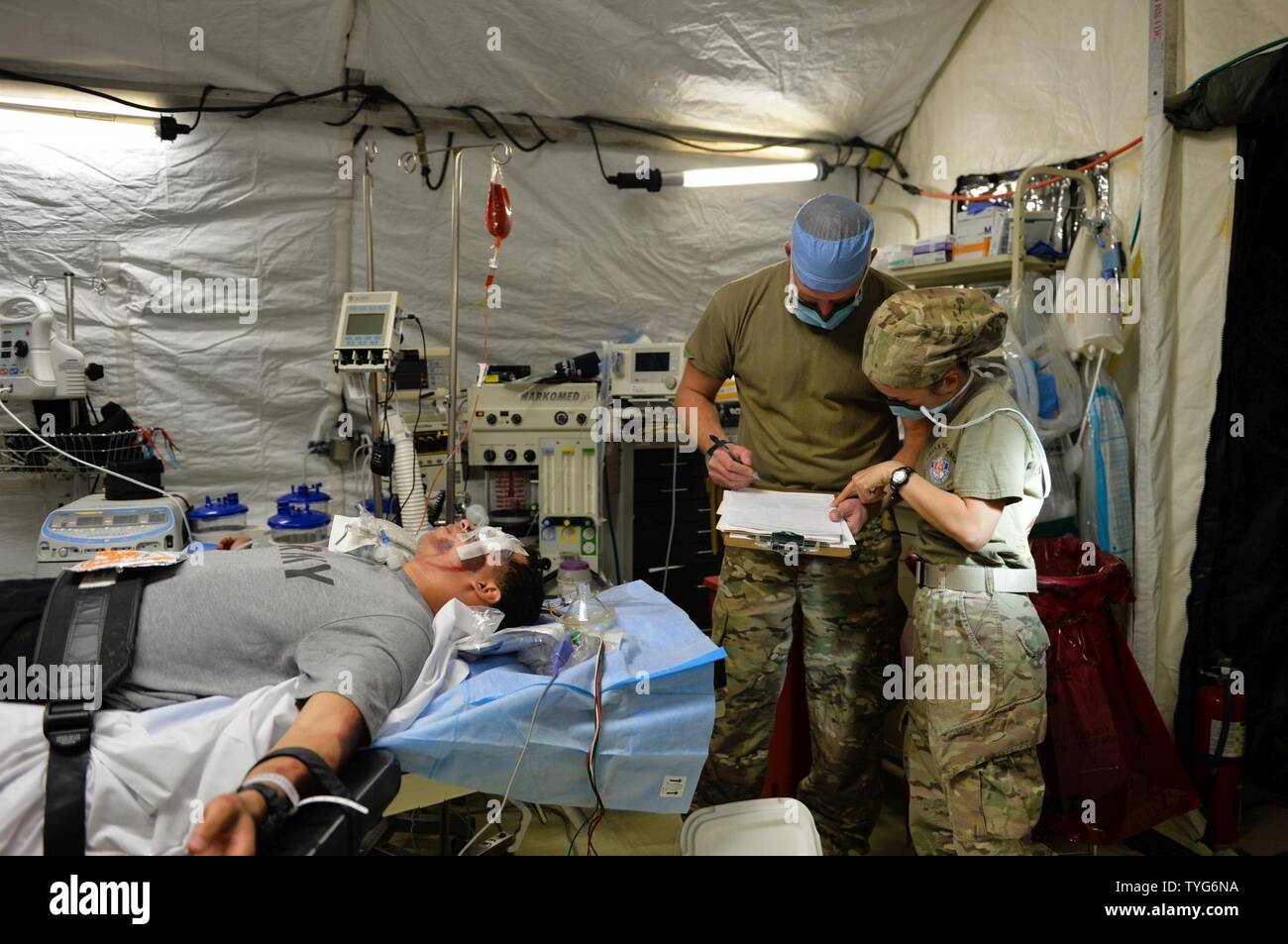 U.S. Army Capt. Gabriel Underwood, center, certified registered nurse ...