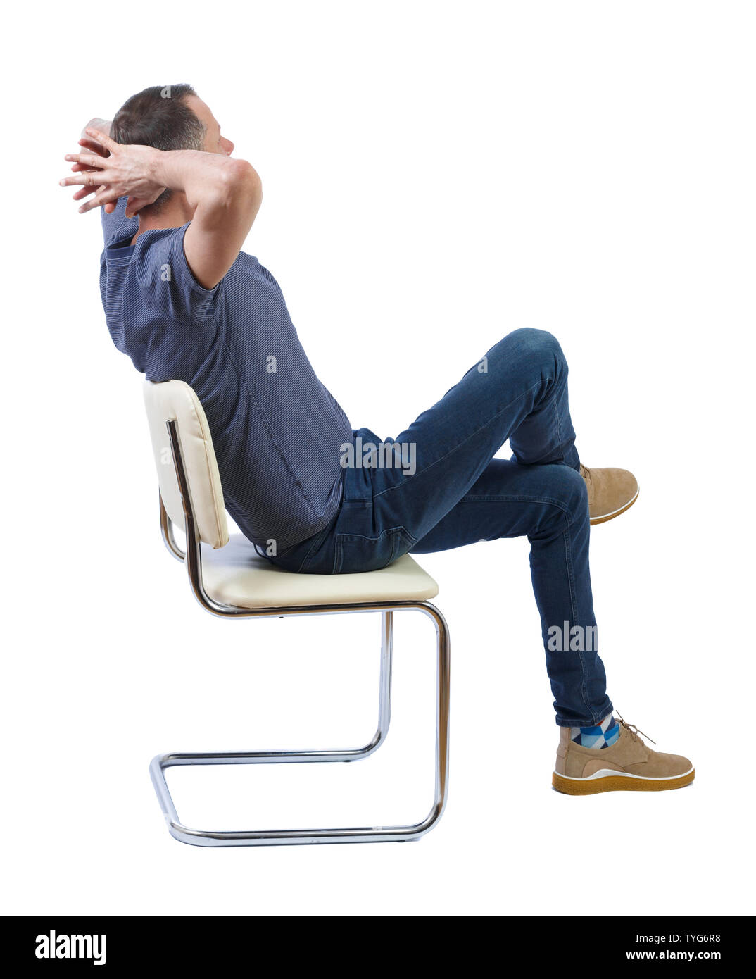 Side view of a man sitting on a chair. Rear view people collection. The student is sitting on a chair relaxed leaning back. backside view of person. I Stock Photo