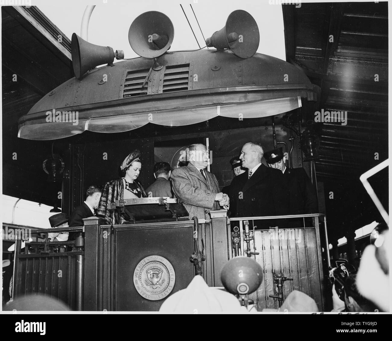 President Harry S. Truman shakes hands with Vice President-elect Alben W. Barkley on the rear platform of the presidential train. Truman and Barkley had just returned to Washington, DC after their victory in the 1948 election. Stock Photo