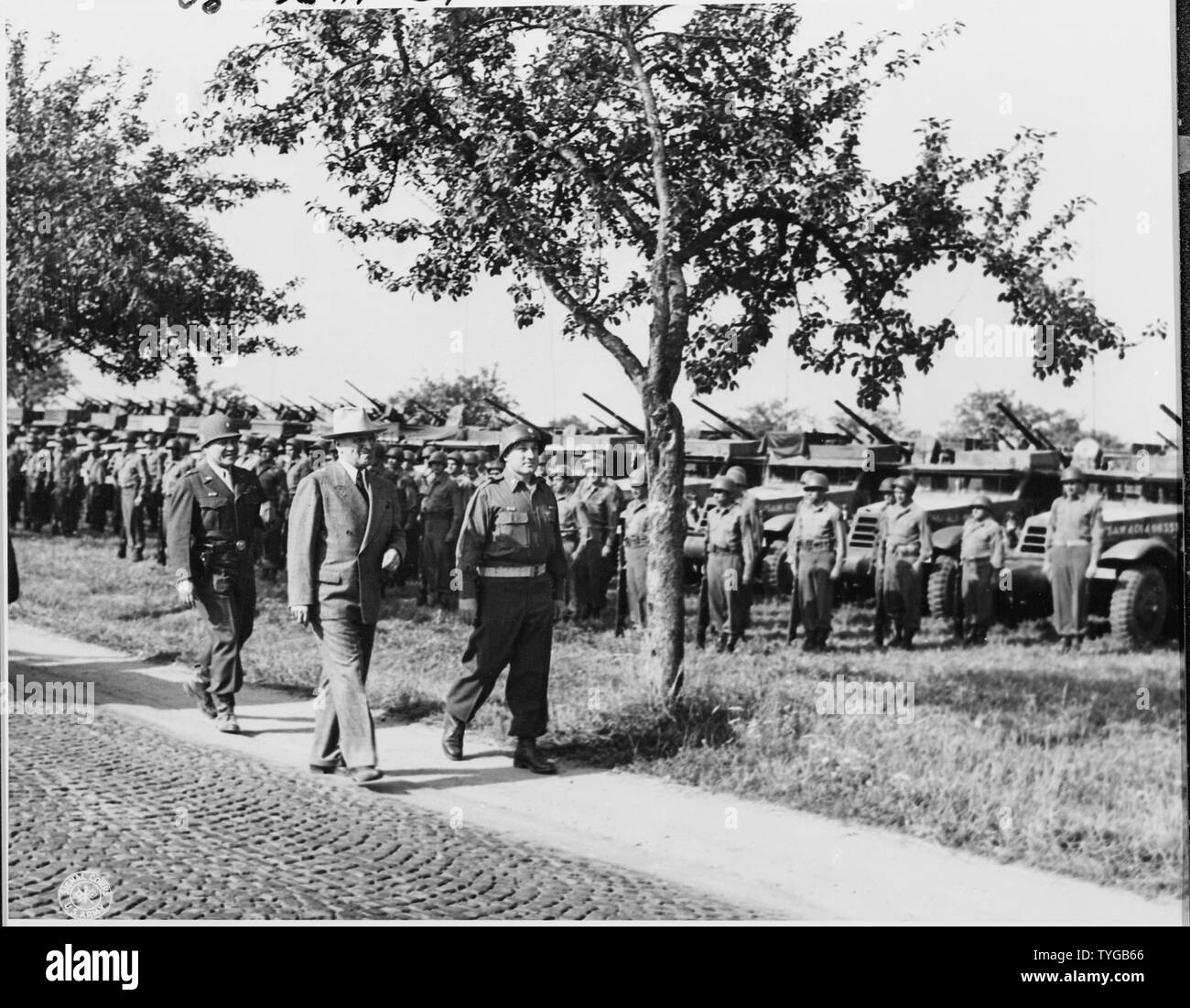 President Harry S. Truman, followed by Brig. Gen. Doyle O. Hickey, Commanding General, 3rd Armored Division, is accompanied to his sedan by the Commanding Officer of the 46th AAA Battalion after making a troop inspection at Neuisenberg, Germany. Stock Photo
