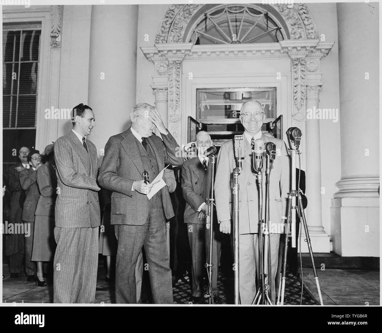 President Harry S. Truman, Vice President-elect Alben W. Barkley, and others standing on the front porch of the White House; President Truman is standing before several microphones. Truman and Barkley had just returned to Washington, DC after their victory in the election of 1948. Stock Photo
