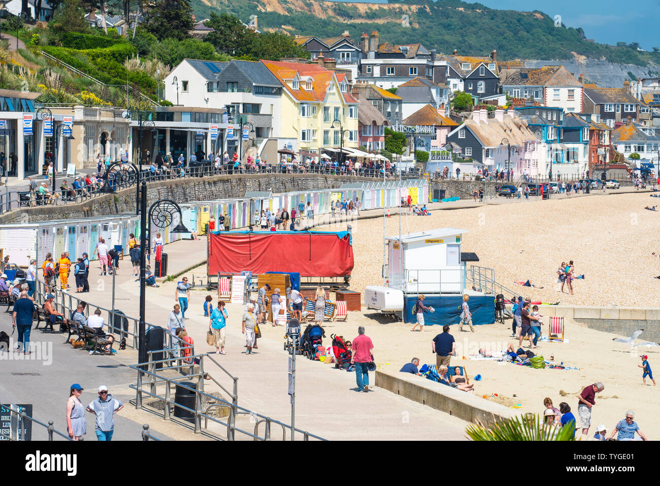 Lyme Regis, Dorset, UK. 26th June 2019. UK Weather:  Visitors bask in scorching hot sunshine  at the picturesque seaside resort of Lyme Regis this afternoon.  The sweltering conditions are set to get even hotter and more humid over the coming days as the 'Saharan heat bubble' hits Southern England. Credit: Celia McMahon/Alamy Live News. Stock Photo