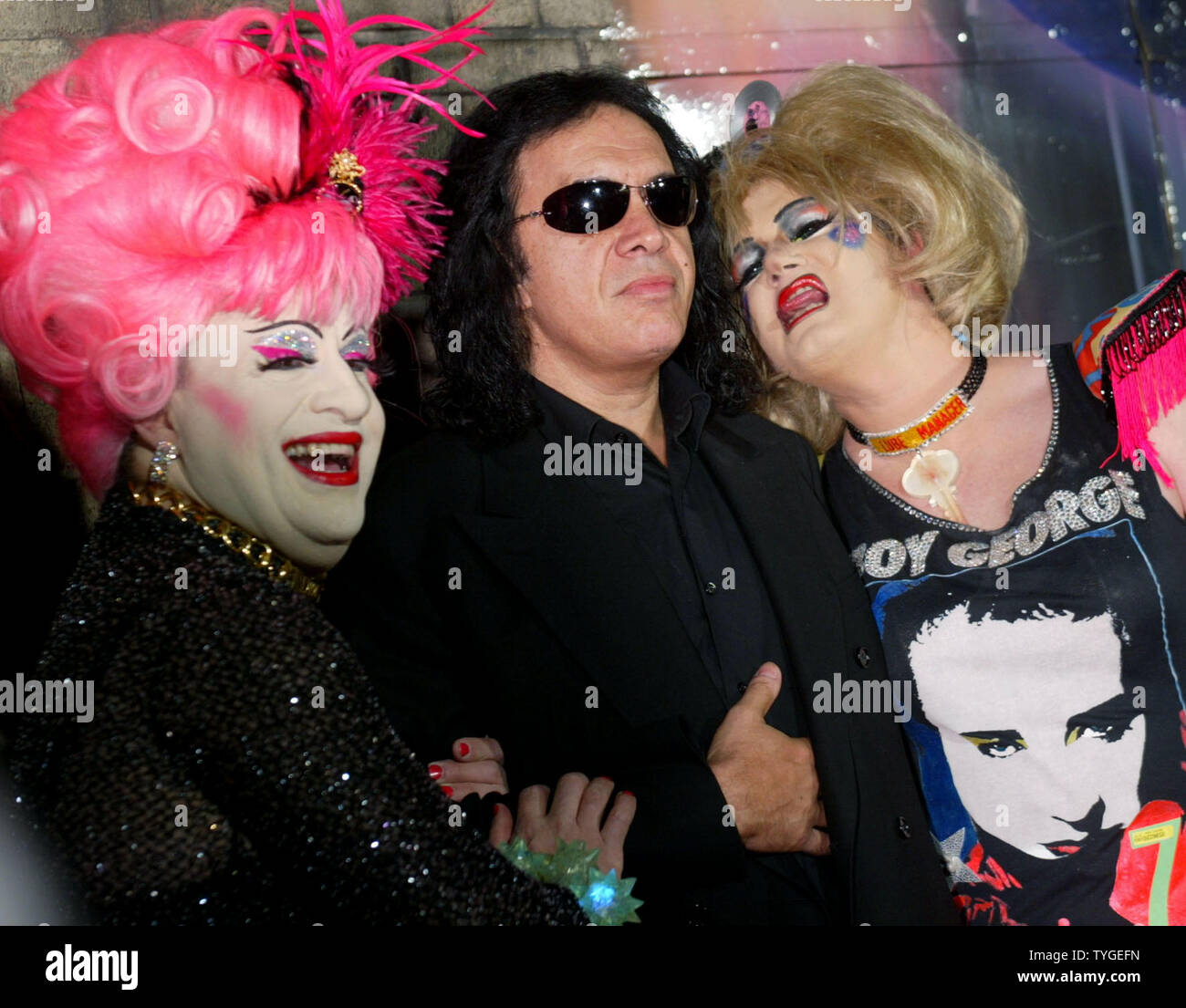 Kiss member Gene Simmons poses with a pair of drag queens as he arrives for opening night of Rosie O'Donnell's Broadway production 'Taboo' on November 13, 2003 in New York City. The play, featuring Boy George, is about the counter culture of the 1980's.  (UPI/MONIKA GRAFF) Stock Photo