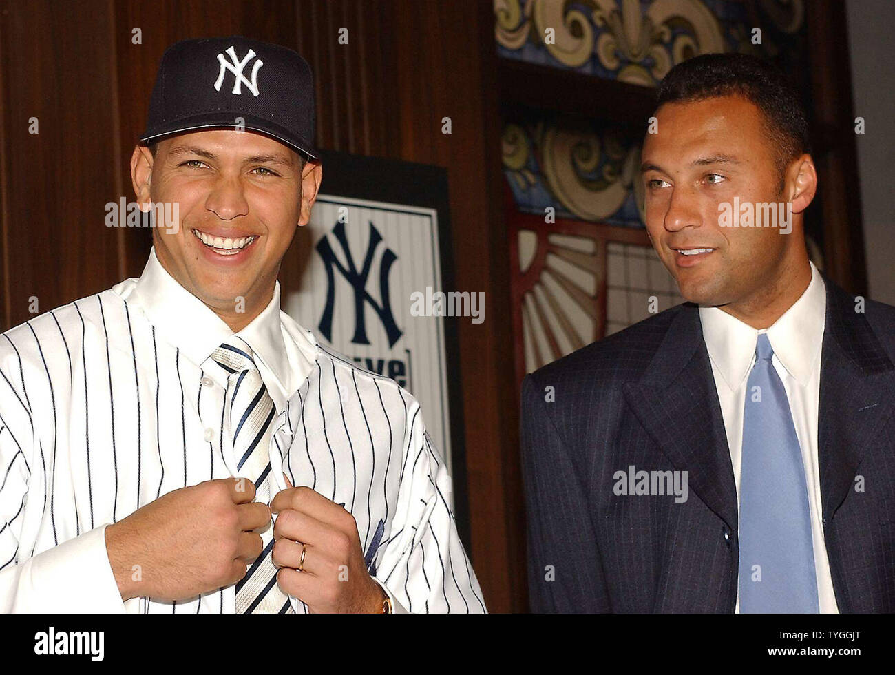 Yankees team captian Derek Jeter looks on while American League Most  Valuable Player Alex Rodriguez adjusts his new uniform shirt during his  Feb. 17, 2004 press conference at New York's Yankee Stadium