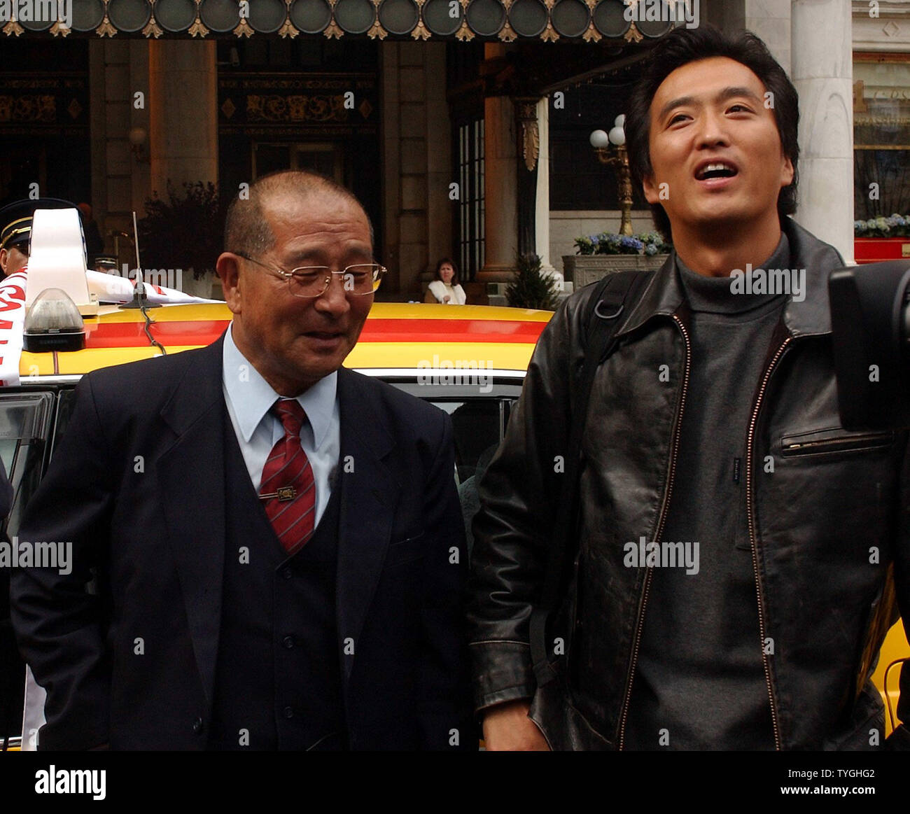 Japanese cab driver Tsyuyoshi Sakuma (left) and actor Gitan Otsuru (guest passenger) celebrate after crossing the finish line outside the Plaza Hotel in New York City on April 2, 2004 after driving from Ushuaia, Argentina on Dec. 23, 2003 to the United States.  (UPI/Ezio Petersen) Stock Photo