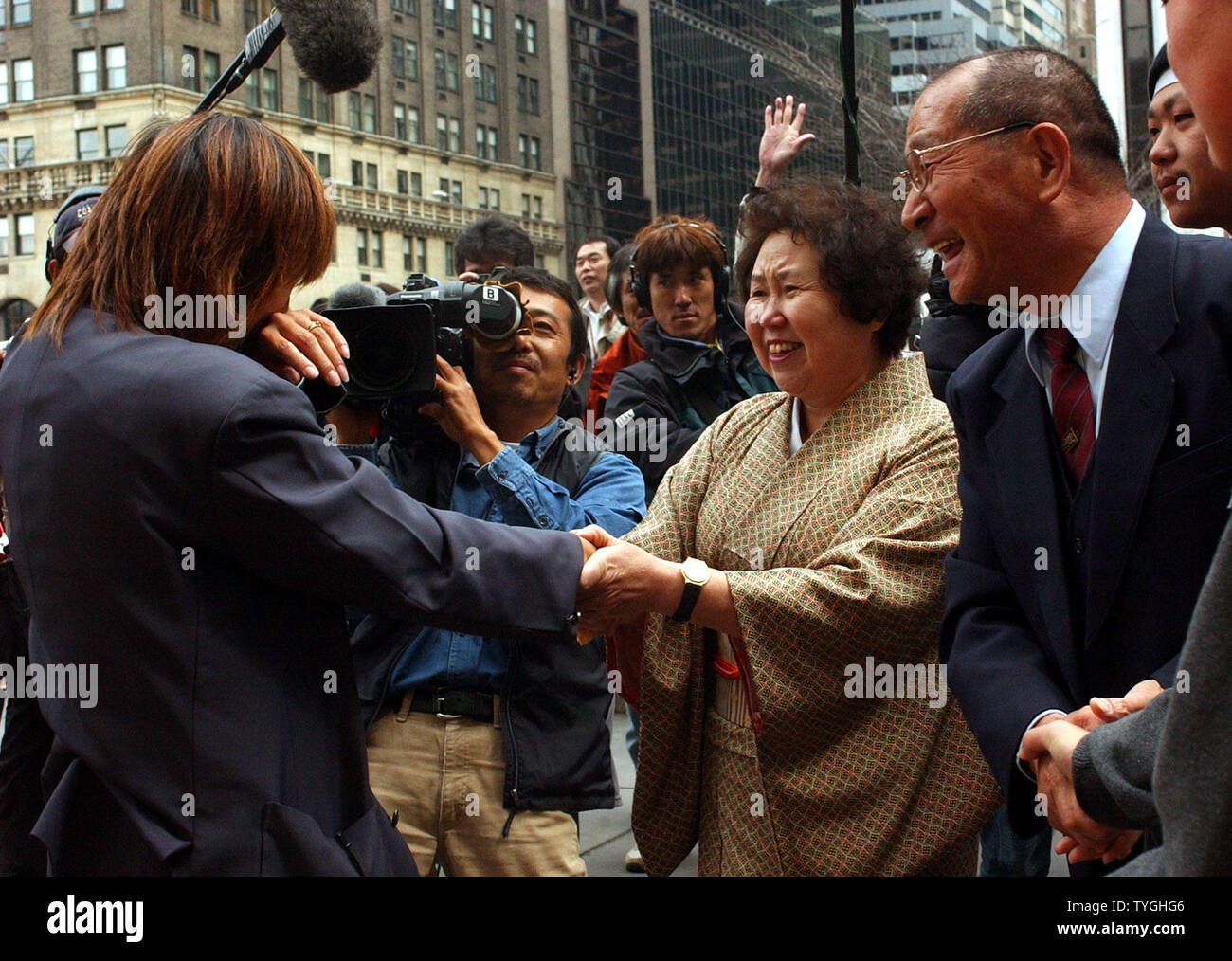 Japanese cab driver Tsyuyoshi Sakuma (right) looks on while his wife Kayuko greets her daughter and co-driver Ayako Sakuma (left)  outside the Plaza Hotel in New York City on April 2, 2004 after father and daughter completed their drive from Ushuaia, Argentina on Dec. 23, 2003 to the United States.  (UPI/Ezio Petersen) Stock Photo