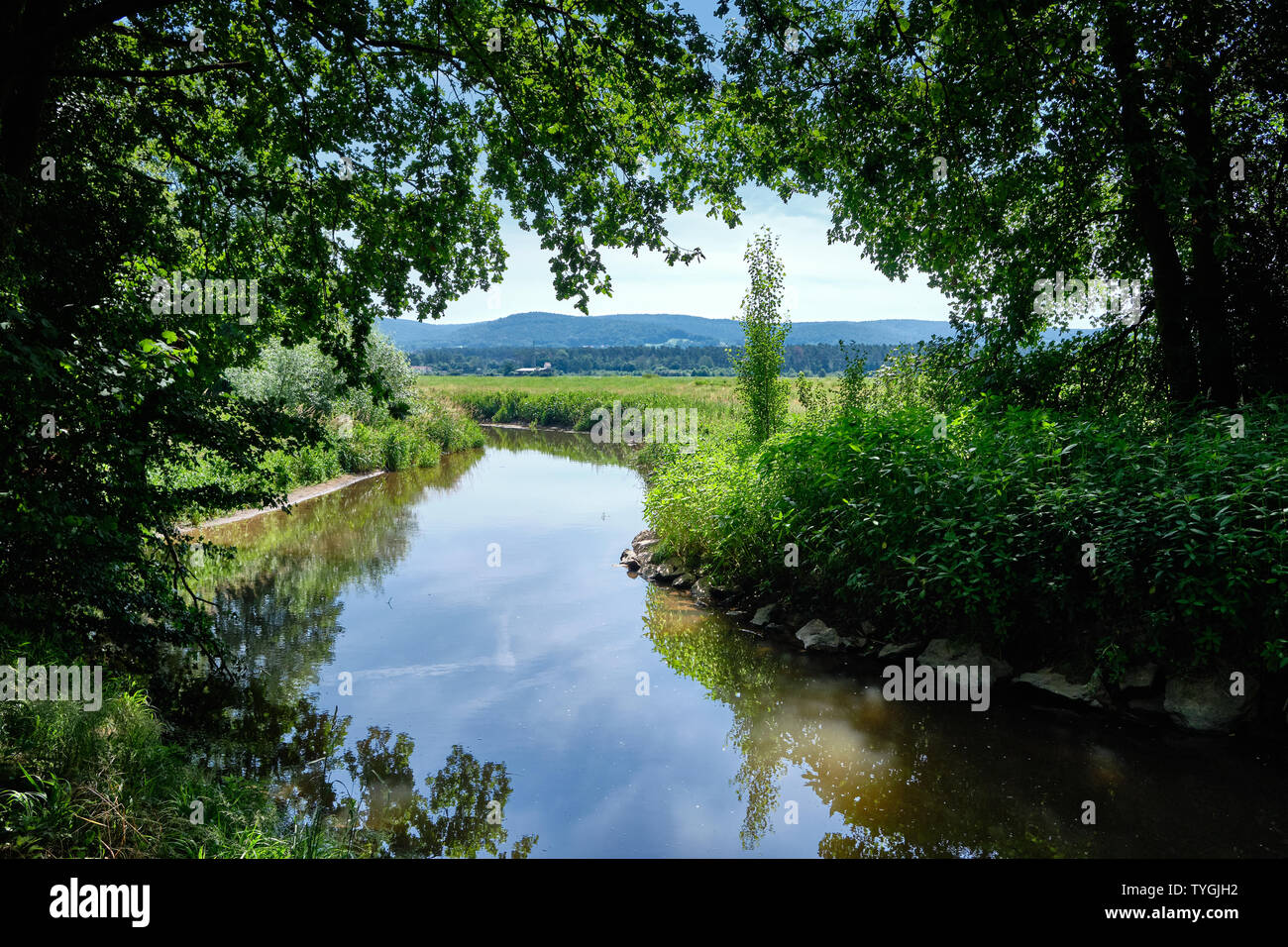 Beautiful scenic view in a landscape near the town Alzenau, Bavaria, Germany, with the river Kahl an the hills of the Spessart in the background Stock Photo