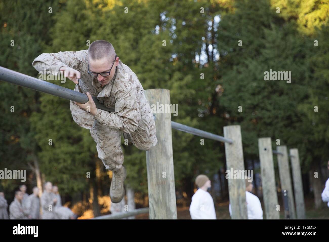 A U.S. Marine candidate with Officer Candidate School (OCS) climbs over a pole during the