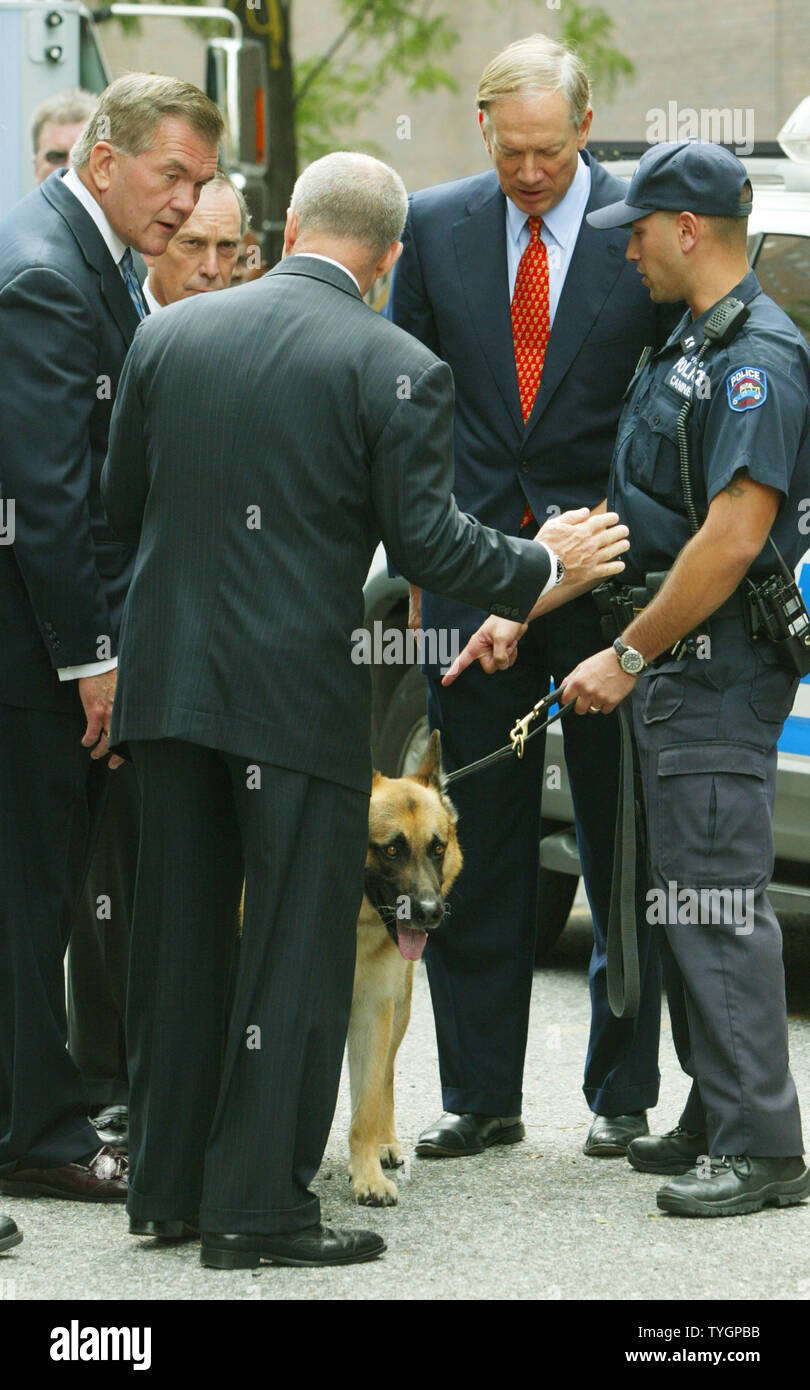 Secretary of Homeland Security Tom Ridge, left, joins police commissioner Raymond Kelly, second left, and New York State governor George Pataki, second right, as they visit a policeman and his K-9 unit as they check out special security vehicles and aparatus at the New York City Police Department's headquarters August 25, 2004 in New York City. Ridge is on hand to discuss security measures with city officials in preparation for the Republican National Convention and the demonstrators it will attract to the city. (UPI Photo/Monika Graff) Stock Photo