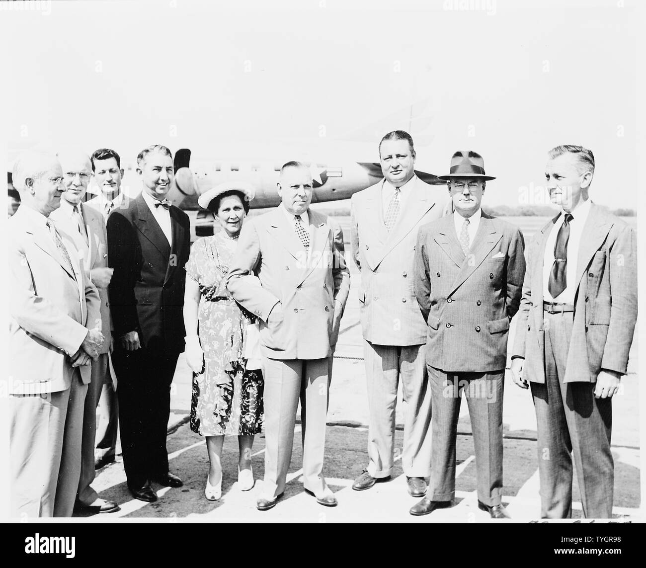 President Truman greets President Romulo Gallegos at the airport where President Gallegos is arriving for a visit to the United States. In this photo are members of President Truman's cabinet, including, L to R: Charles Sawyer, Charles Brannan, unidentified man in background, Tom Clark, unidentified woman, Jesse Donaldson, J. A. Krug, John Snyder, James Forrestal. Stock Photo