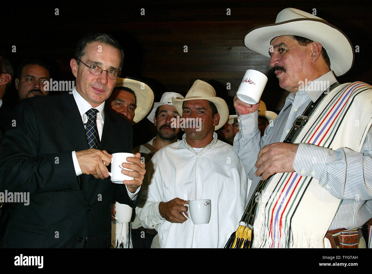 Colombian President Alvaro Uribe (L) and Juan Valdez (right), the icon of Colombian coffee, toast with coffee cups at the opening of the Juan Valdez Cafe in New York in New York on September 28, 2004.  (UPI Photo/Laura Cavanaugh) Stock Photo
