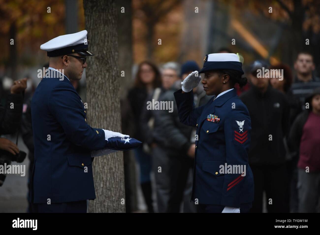 NEW YORK – U.S. Coast Guard Petty Officer 1st Class Tija Hopkins salutes Chief Petty Officer Juan Calderon during a ceremony honoring the Official Grand Marshals for the 2016 New York City Veterans Day Parade at the Freedom Tower in New York, Nov. 9, 2016. Calderon and Hopkins are both members of the U.S. Coast Guard Sector New York Ceremonial Color Guard. Stock Photo