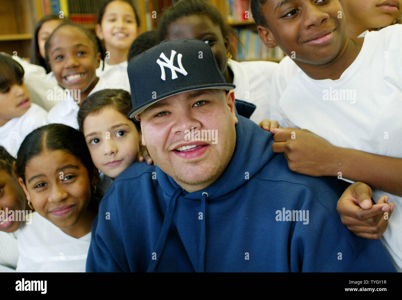 Joseph Cartegena, known as hip-hop artist Fat Joe, poses with students at PS 146 where he donated 20 new computers to the Bronx school, which he attended as a child, on December 21, 2004 in New York City.  (UPI Photo/Monika Graff) Stock Photo