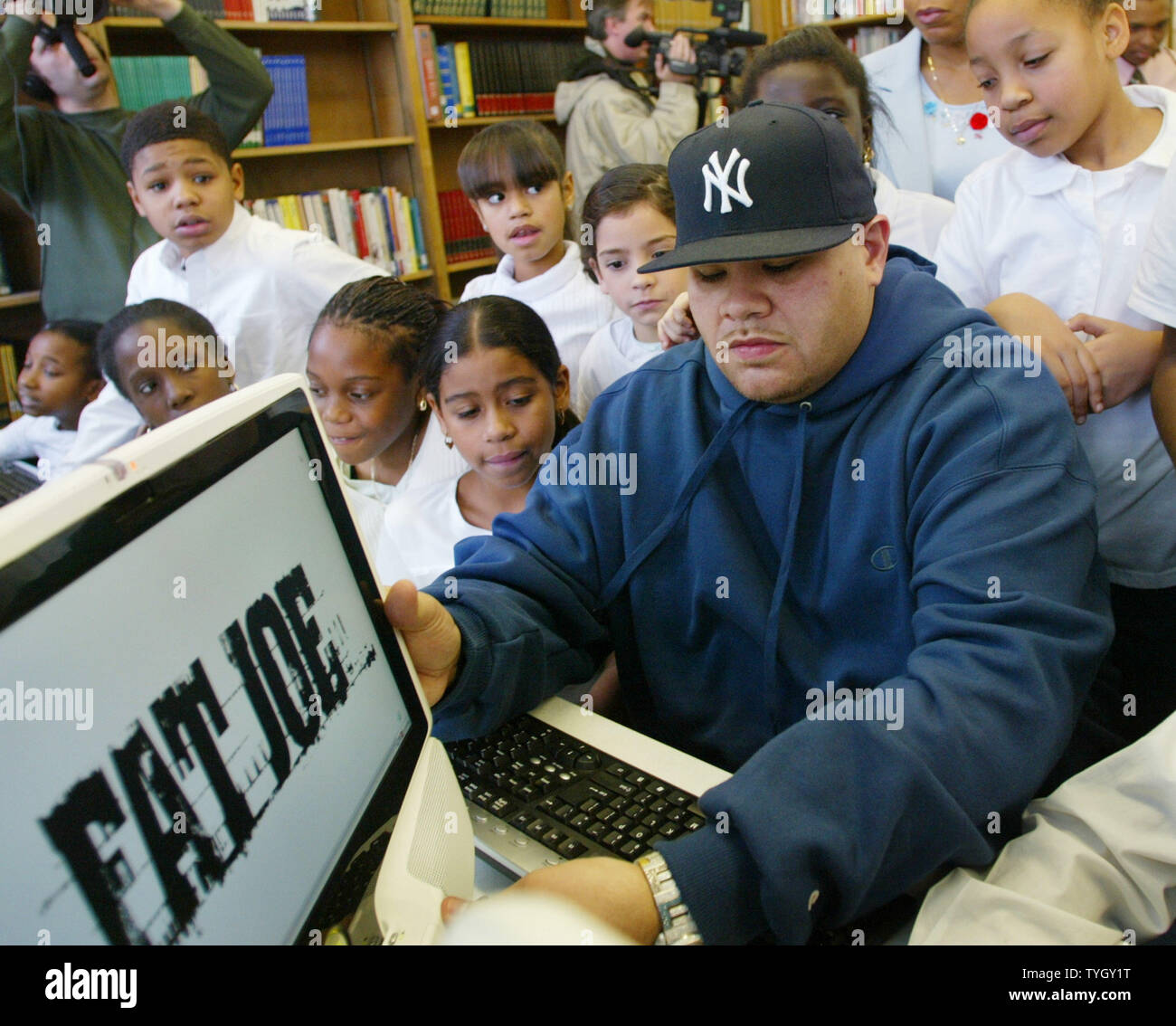 Joseph Cartegena, known as hip-hop artist Fat Joe, is joined by students at PS 146 as he checks out one of the 20 new computers that he donated to the Bronx school, which he attended as a child, on December 21, 2004 in New York City.  (UPI Photo/Monika Graff) Stock Photo