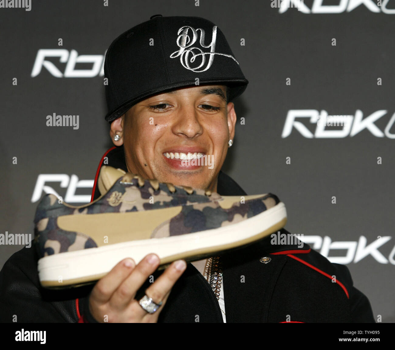 Daddy Yankee poses looks at his new sneaker at the Reebok RBK Now Playing  press conference at Marquee in New York City on March 8, 2006. (UPI  Photo/John Angelillo Stock Photo - Alamy