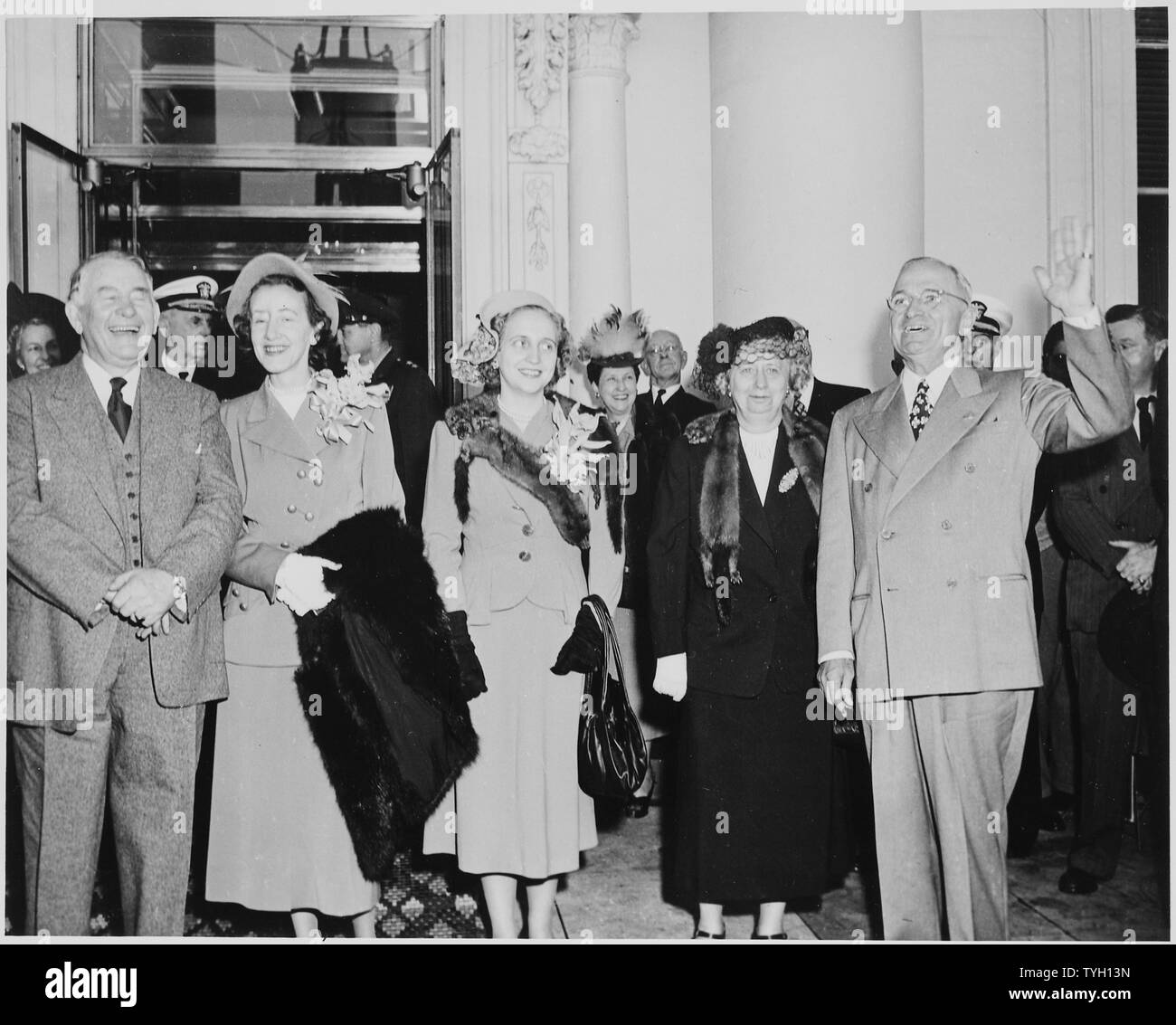 President and Mrs. Harry S. Truman, Vice President-elect Alben W. Barkley and Mrs. Max Truitt, and Margaret Truman standing on the front porch of the White House, with other standing behind them. Truman is waving. Truman and Barkley had just returned to Washington, DC after their victory in the 1948 election. Stock Photo