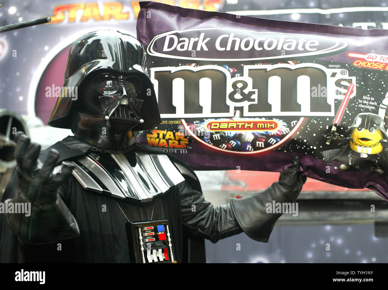 Star Wars character Darth Vader holds up a model of the new Star War-themed M&M's which is unveiled in Time Square on March 29, 2005 in New York City. Masterfoods USA, the makers of M&M's, is marketing a dark chocolate version of the popular candy as they promote the movie 'Star Wars:Episode III Revenge of the Sith.' (UPI Photo/Monika Graff) Stock Photo