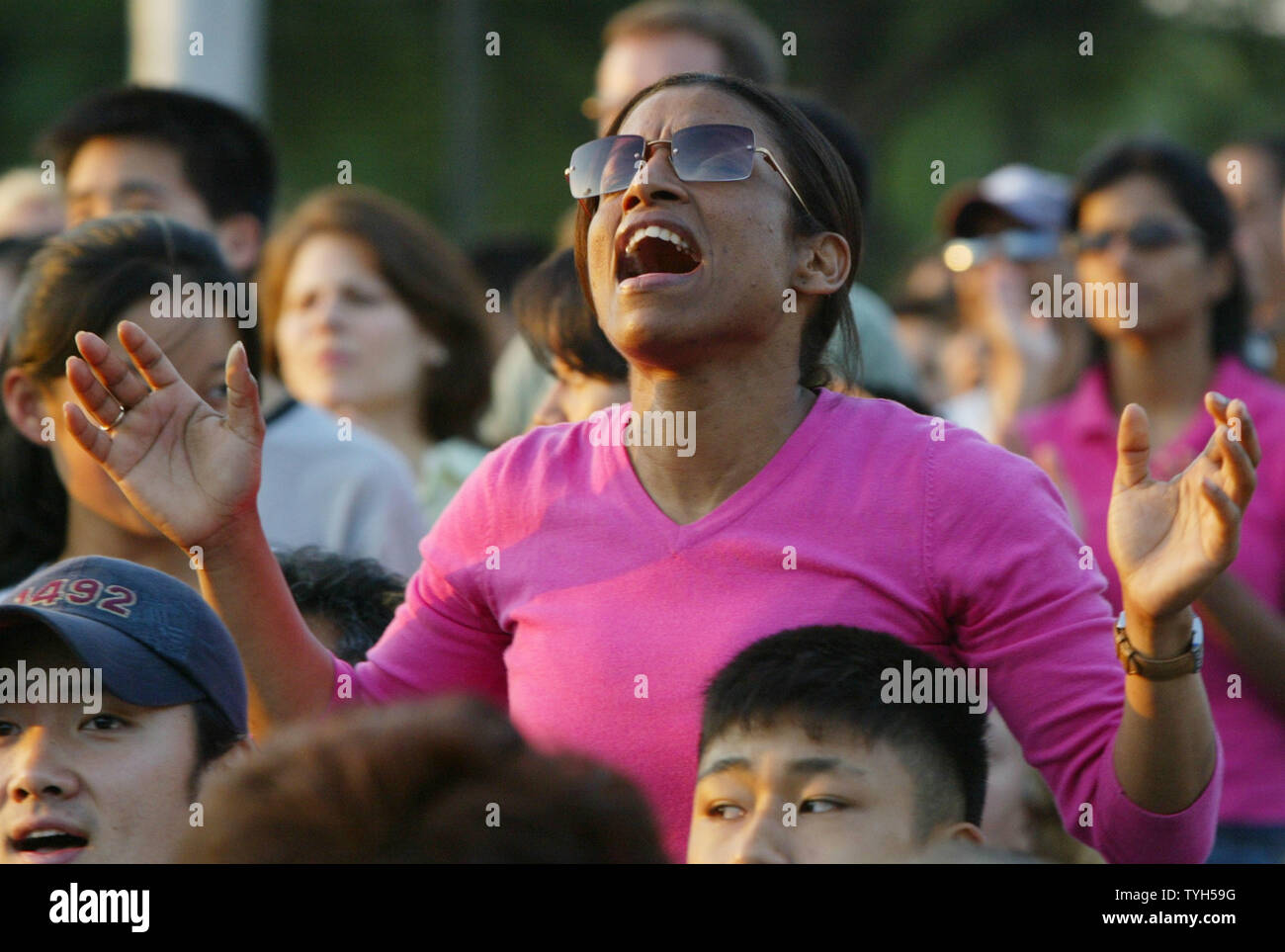 Dahlia Mozam joins the tens off thousands of worshippers in prayer at the Greater New York Billy Graham Crusade held at Flushing Meadows Park on June 24, 2005 in New York City. The three-day event will be Graham's last crusade as the 86-year-old acknowledges that various illnesses are forcing him to retire. (UPI Photo/Monika Graff) Stock Photo